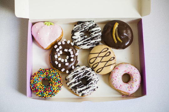 Colorful donuts in a takeaway box
