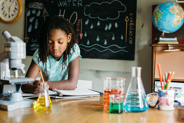 Girl taking notes in a chemistry class