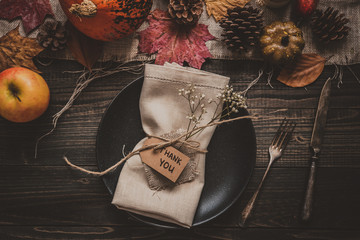 Thanksgiving background. Thanksgiving decoration with cutlery and plate on the wooden table, top view