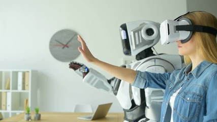 Girl wearing vr headset experimenting with robotic machine