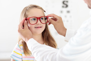 Child at eye sight test. Kid at optitian. Eyewear for kids.
