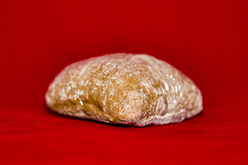 French appetizing rye bun in cellophane on a red background
