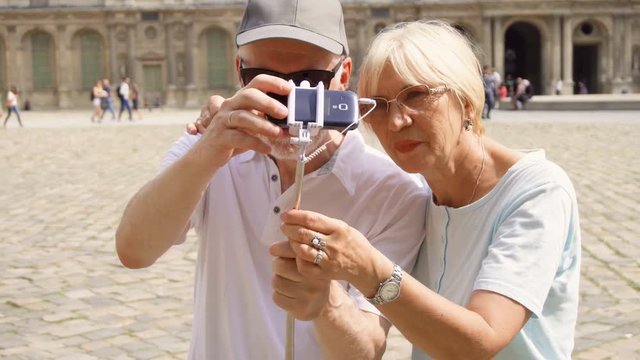 Senior couple making selfie with smartphone on vacation in Paris. Having fun, happy traveling together.
