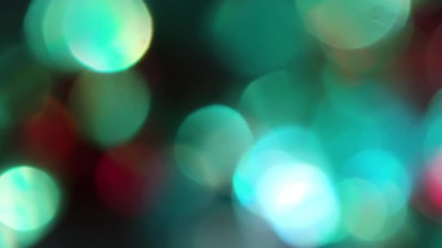 The Circles Bokeh stock video features a circle rotation in a clockwise direction of blurred turquoise, green and red lights. You can use it as an overlay for creative video effects, artistic videos