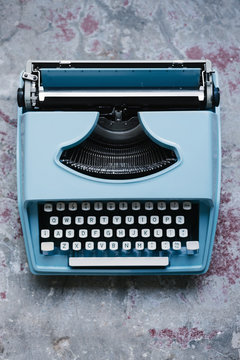 Blue Retro Typewriter Against A Concrete Background