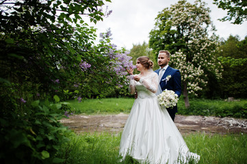 Stunning wedding couple enjoying each other's company in park with blossoming trees on the...