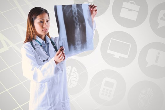 Composite image of asian doctor checking mri scan