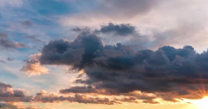 Time lapse clip of evening fluffy curly rolling clouds with sunset and rising arrows