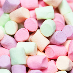 Colorful mini marshmallows background macro. Fluffy marshmallows texture and pattern. Flat lay or top view. Winter food background concept.