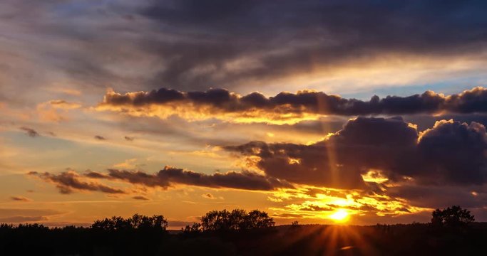 Time lapse clip of evening fluffy curly rolling clouds with sunset and rising arrows