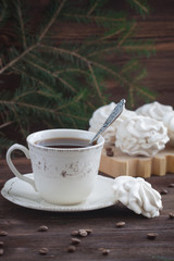 A cup of coffee with coffee flavoured zephyr or marshmallows on wooden background