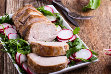 Roast pork fillet with with arugula and radish salad