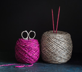 Fuchsia and grey tweed yarn on the dark wooden background