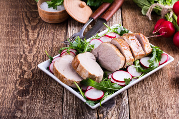 Roast pork fillet with with arugula and radish salad