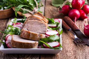 Roast pork fillet with with arugula and radish salad