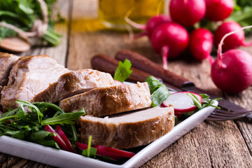 Roast pork fillet with with arugula and radish salad