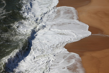 Fototapeta na wymiar Ecume des vagues sur le sable