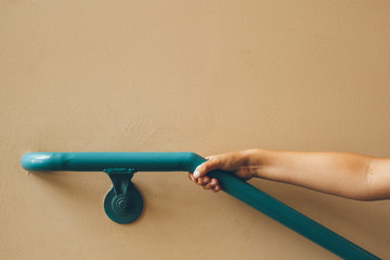 child's arm holding onto a railing