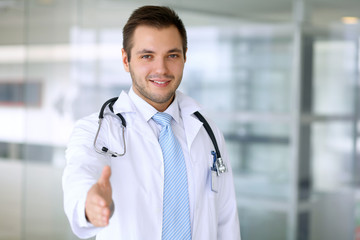Smiling male doctor is ready for handshake 