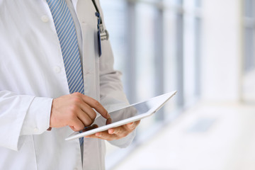 Doctor using a digital tablet, close-up of hands. Health care concept 