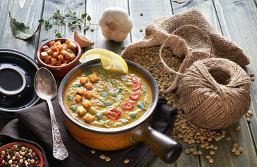 Spicy lentil soup with chili, garlic and onion on wooden table