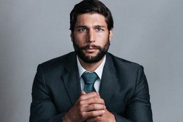 studio portrait of full bearded well dressed young business man looking in the camera