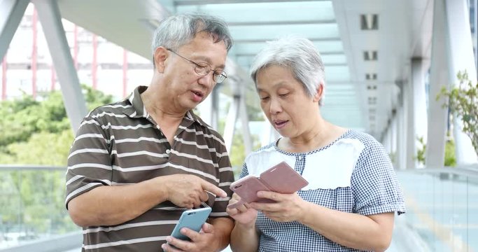 Old couple looking at mobile phone together