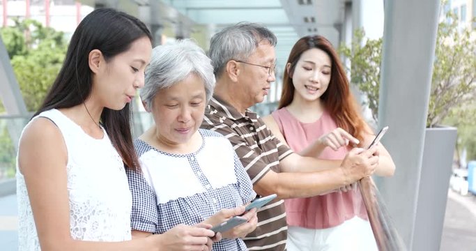 Family using mobile phone together at outdoor