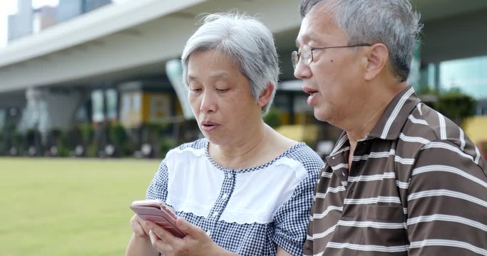 Senior couple using cellphone together