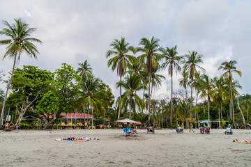Obraz premium MANUEL ANTONIO, COSTA RICA - MAY 13, 2016: People on a beach in Manuel Antonio village, Costa Rica