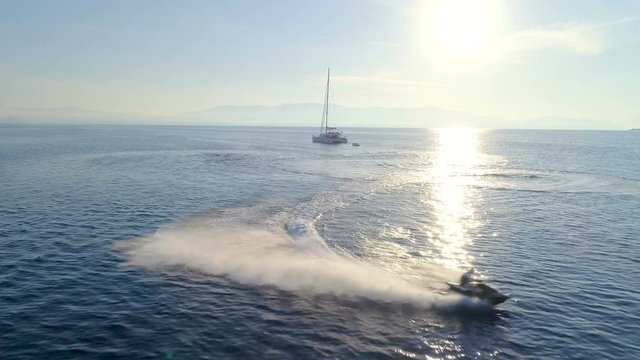 Aerial View of the White Sailing Catamaran Yacht and Jet Ski Driving in Circles Near by