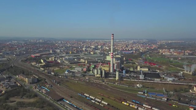 Flight over heating plant and thermal power station. Aerial view of combined modern power station for city district heating and generating electrical power. Industrial zone with railway in the city.