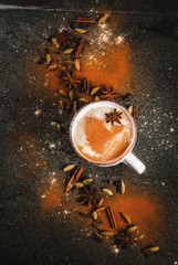 Traditional indian masala chai tea with spices - cinnamon, cardamom, anise, dark stone background. Copy space top view