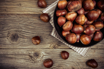 chestnuts in a pan on a wooden background