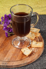 a cup of coffee with cookies on a wooden tray