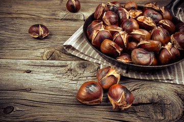 chestnuts in a pan on a wooden background
