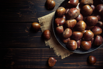 chestnuts in a pan on a wooden background