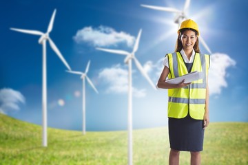 Composite image of architect woman with yellow helmet and plans