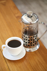 Coffee pot and a coffee cup on wood table
