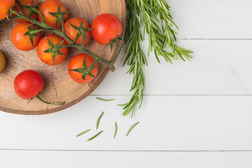Organic cherry tomatoes with rosemary on rustic wooden table