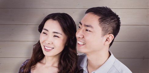 Composite image of cheerful couple looking away