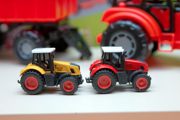 Obraz premium Yellow and red traxtor toys in the background without focus