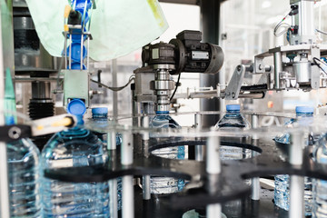 Bottling plant - Water bottling line for processing and bottling carbonated water into blue bottles. Selective focus. 