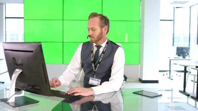  Phone operator with police service assisting a caller, with green background