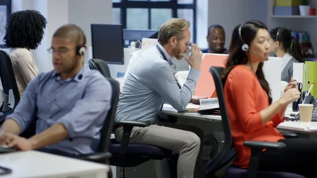 Fed up businessman sitting at his desk looking depressed