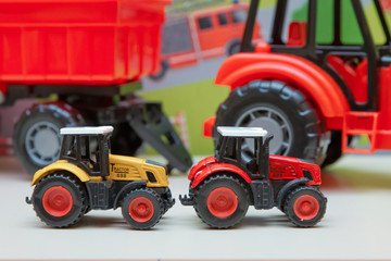 Yellow and red traxtor toys in the background without focus