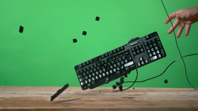  Keyboard smashed down on desk & shattering, shot in super slow motion