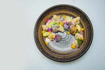 Fine art vegan dining, corn bread with several vegetables in a brown plate