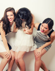 Three beautiful fashionable laughing young girls having fun