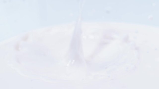  Fresh red strawberry dropping into bowl of cream, close up & in slow motion